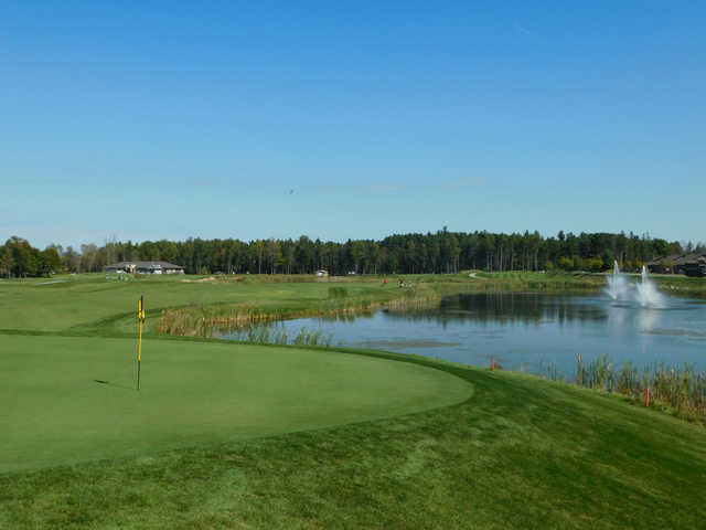 A view of a green with a pond on the right side at eQuinelle Golf Club.