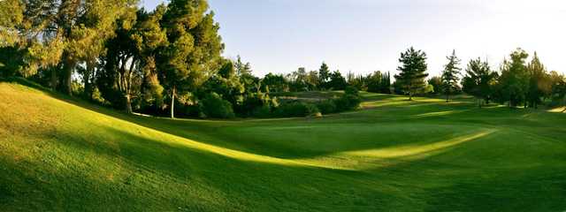 A sunny day view of a green at Jurupa Hills Country Club.