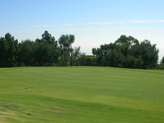 A sunny day view of a hole at Los Verdes Golf Course.