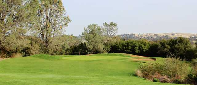 A sunny day view of a hole at Castle Oaks Golf Club.