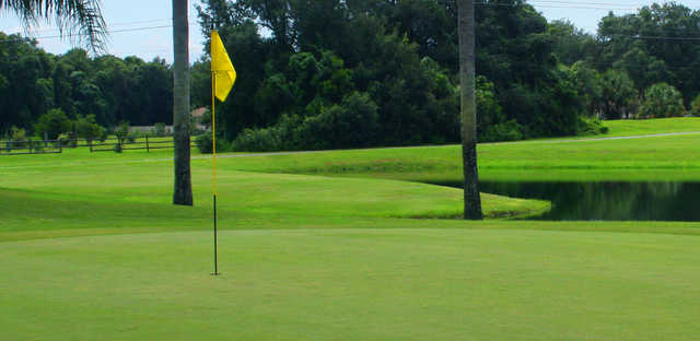 A view of a green with water in background at The Groves Golf Course.