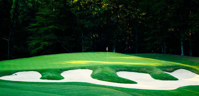 A view of a green guarded by an elegant bunker from The Club At Viniterra.