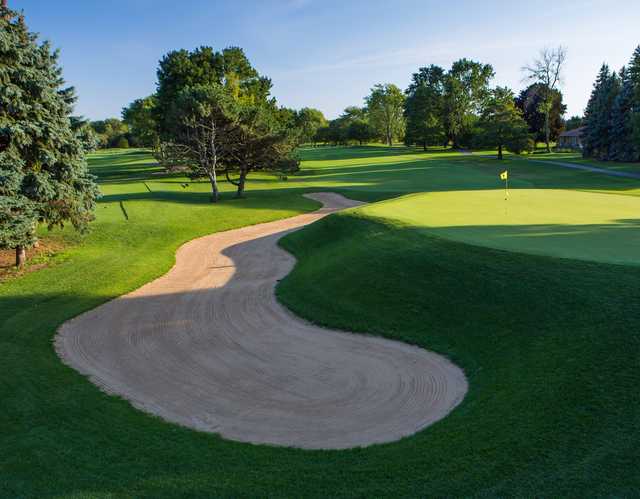 A view of a green protected by an elegant bunker at Mt. Prospect Golf Club.