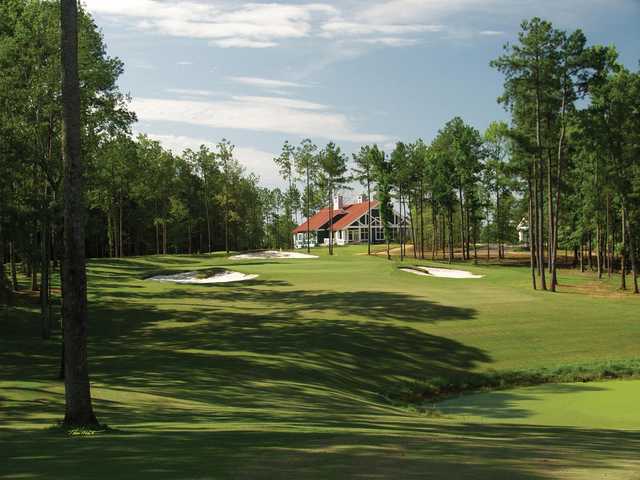 A view of a green surrounded by bunkers and the clubhouse in background from Arrowhead Pointe At Lake Richard B. Russell.