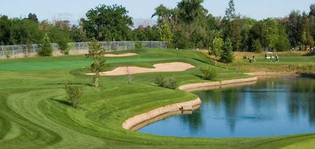 A sunny day view of a hole at Los Lagos Golf Course.