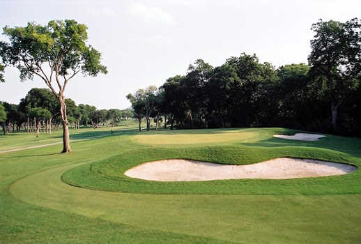A view of green guarded by bunkers at Pecan Valley Golf Club