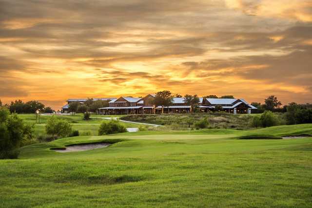 A sunset view of the clubhouse and a green at The Golf Club of Texas.
