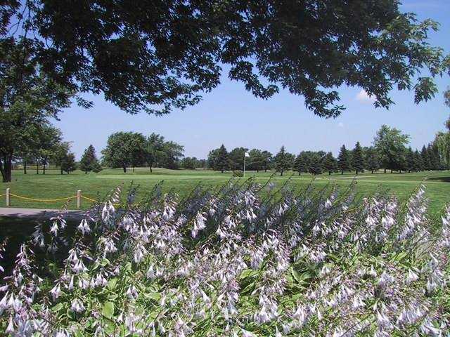 A view of a green surrounded by flowers at University Park Golf Club.