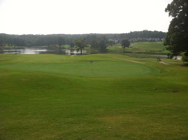A view of a green with water in background at the Country Club of Gwinnett.