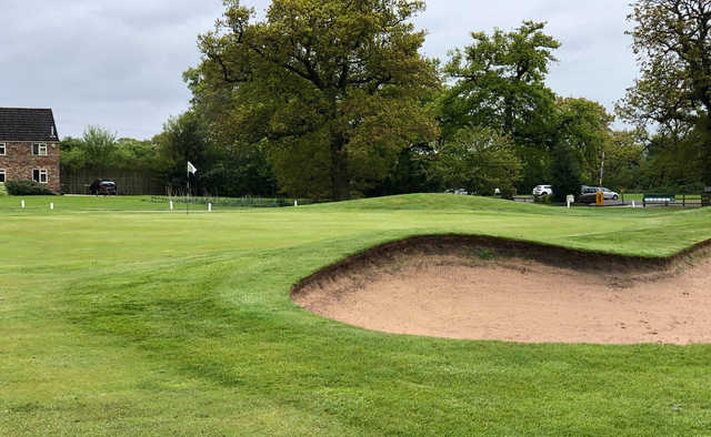 A view of a green protected by a huge bunker at Forest of Galtres Golf Club.