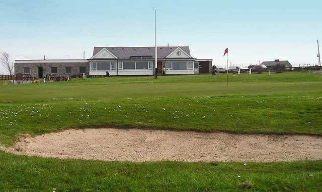 A view of a green and the clubhouse at Anglesey Golf Club.